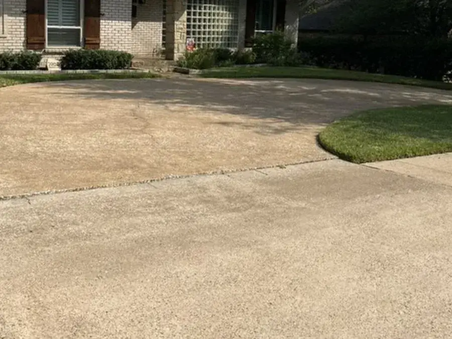 Bright, freshly pressure washed concrete driveway at a Dallas home