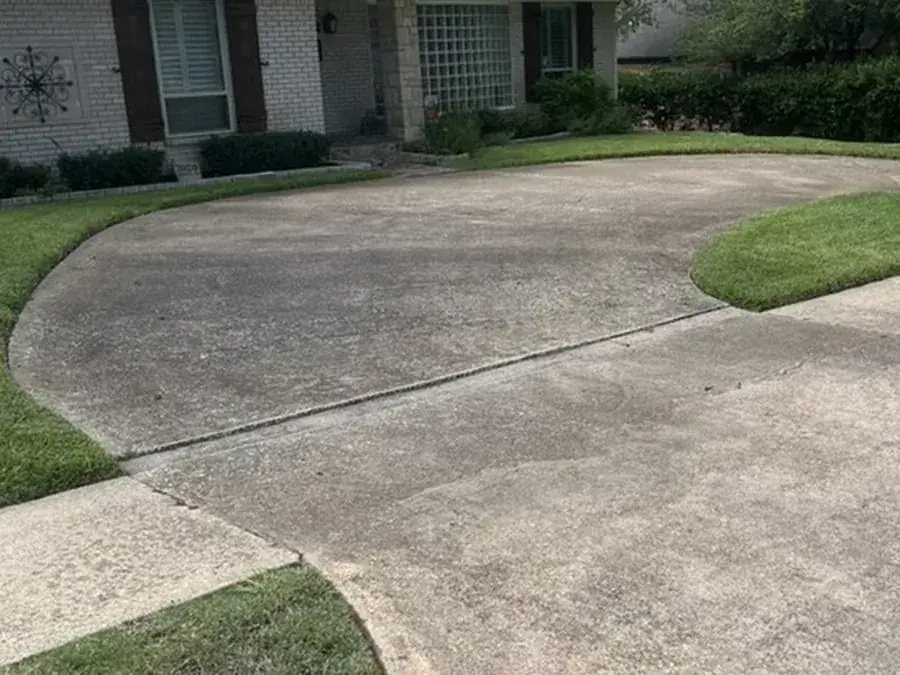 Concrete driveway stained with dirt and algae before pressure washing